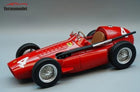 Red diecast Ferrari racing model car with number 4 and wire-spoke wheels on gray background