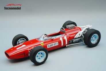 Red diecast Ferrari Formula 1 model car with white details and number 11, displayed on grey background.