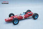 Red diecast Ferrari Formula 1 model car with blue wheels and driver figure on light background