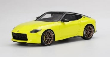 Yellow diecast model sports car with black roof and bronze wheels on white background