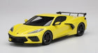Yellow 1:18 scale diecast model sports car with rear spoiler on white background