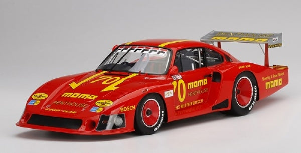 Red diecast Porsche race car model with yellow MOMO livery and large rear wing