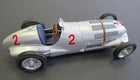 Silver vintage diecast model race car with red number 2, detailed wheels, open cockpit