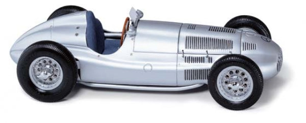 Silver vintage diecast model race car with detailed wheels and blue interior, 1:18 scale.