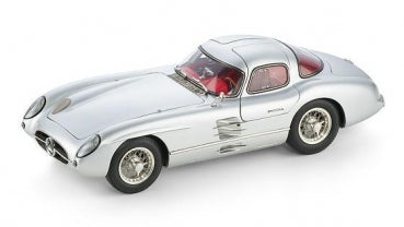 Silver diecast model car coupe in 1:18 scale with red interior on white background