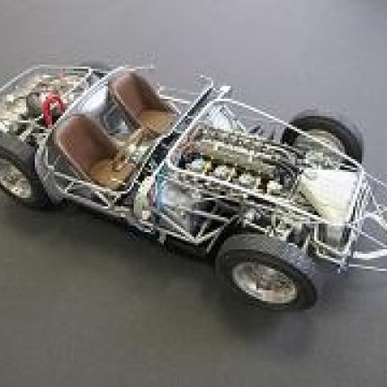 1:18 scale diecast model car chassis with exposed engine, brown seats, and detailed frame