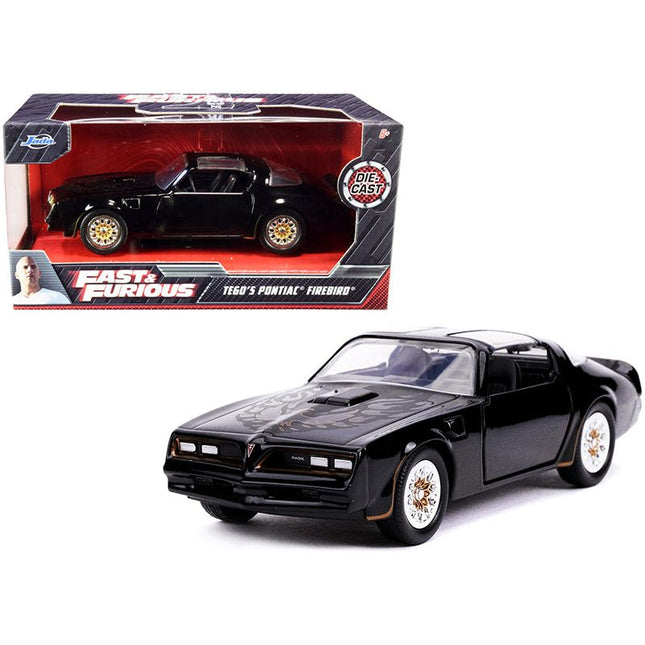 https://cdn.shopify.com/s/files/1/0504/9925/6496/files/tegos-pontiac-firebird-black-with-gold-stripes-and-hood-bird-fast-furious-series-132-diecast-model-car-by-jada-405606.jpg?v=1748419233