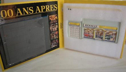 Renault model car display set in yellow packaging, includes diorama pieces and booklet.